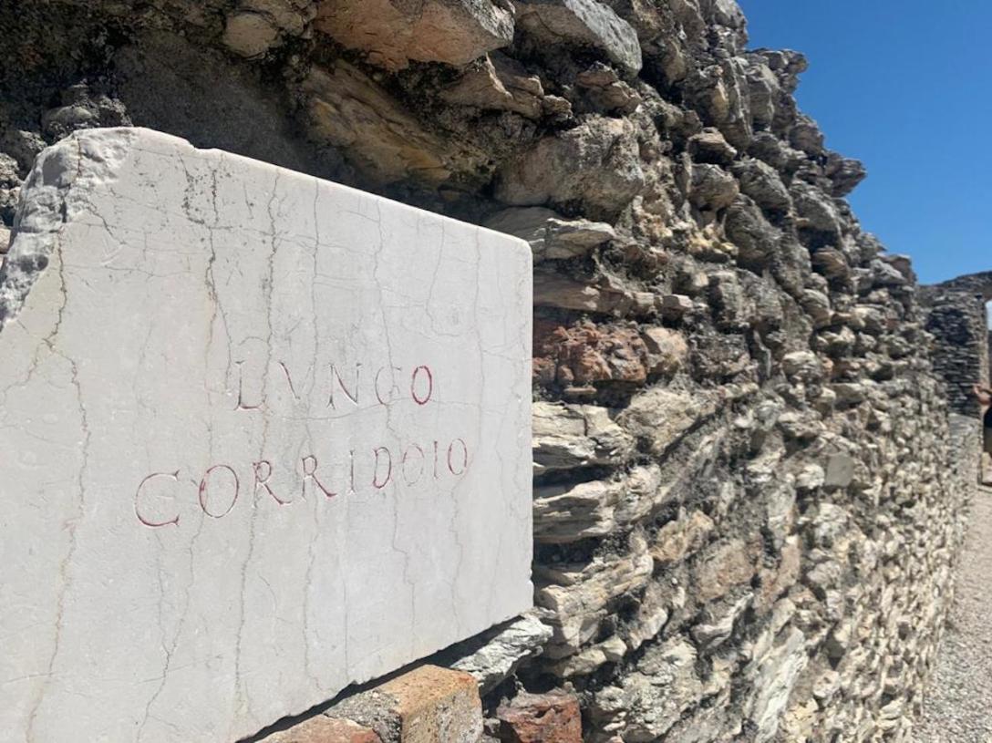 ruínas romanas com placa escrita lungo corridoio